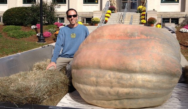 Man next to a giant pumpkin